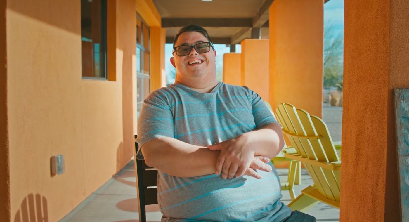 A Treasure House resident smiling on a sunlit patio